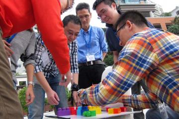employees collaborate to complete breakthrough team building activity bt