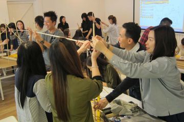 employees collaborate to complete bridging the divide creative team building activity