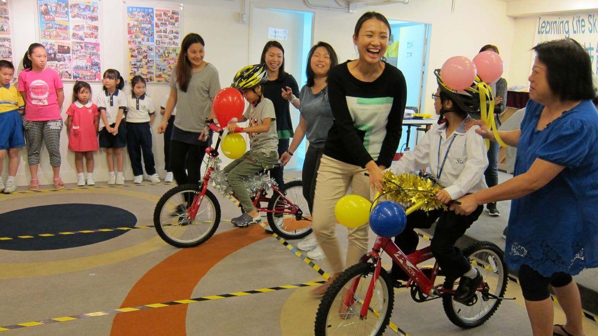 smiling women give newly built bikes to happy children macau