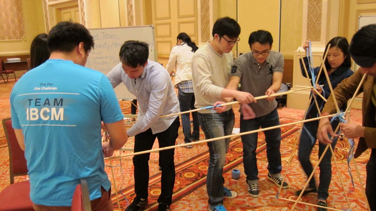 employees collaborate to complete innovative team building programme