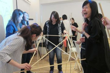 women collaborate to complete bridging the divide creative team building activity