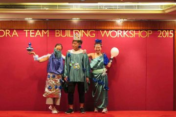 two women and one man dressed up on stage for haute couture team building activity