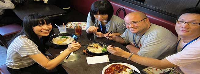 people having a fun time eating noodles