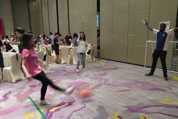 woman kicking ball in the goal team building activity