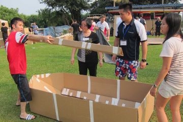 team collaborate to build a cardboard race boat flat out afloat team building challenge
