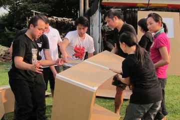 team collaborate to build a cardboard race boat flat out afloat team building challenge